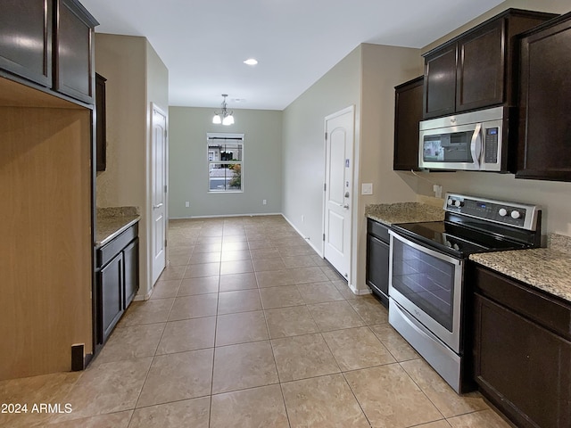 kitchen featuring light tile patterned floors, stainless steel appliances, dark brown cabinetry, and light stone countertops