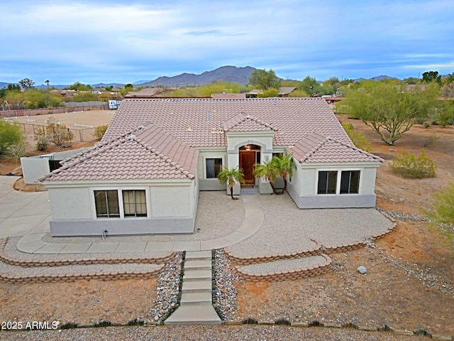 mediterranean / spanish-style home featuring stucco siding, a mountain view, and a tiled roof