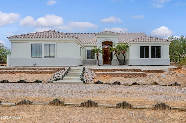 mediterranean / spanish-style home featuring a tile roof and stucco siding