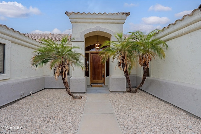 property entrance with a tiled roof and stucco siding