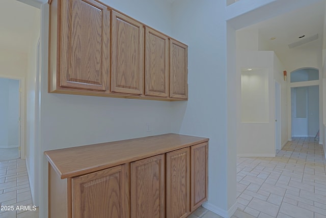 hall with light tile patterned floors and baseboards