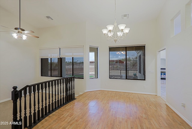 empty room with wood finished floors, visible vents, and a healthy amount of sunlight