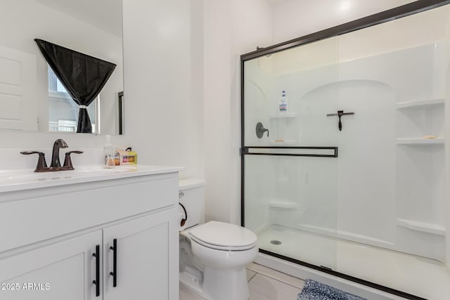 full bathroom featuring a shower stall, toilet, and vanity