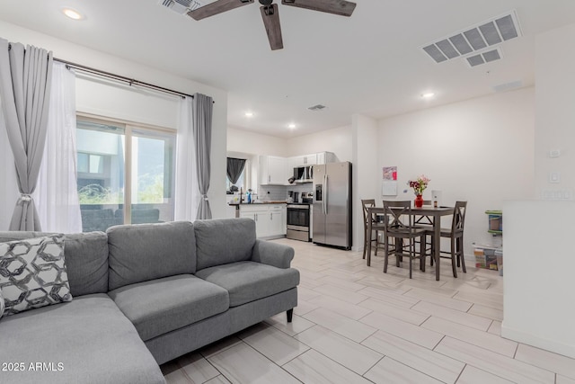 living area featuring ceiling fan, visible vents, and recessed lighting