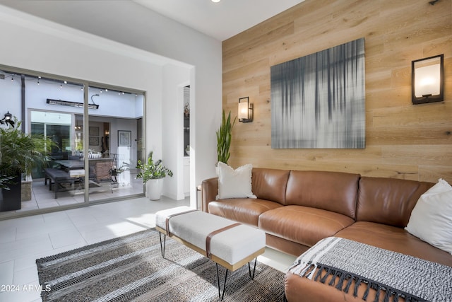 living room featuring tile patterned floors and wood walls