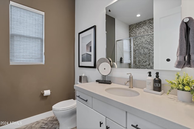 bathroom featuring vanity, toilet, and tiled shower