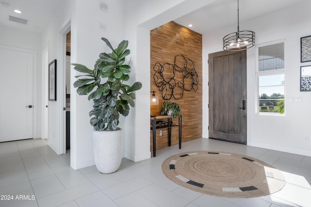 foyer entrance featuring light tile patterned floors and a chandelier