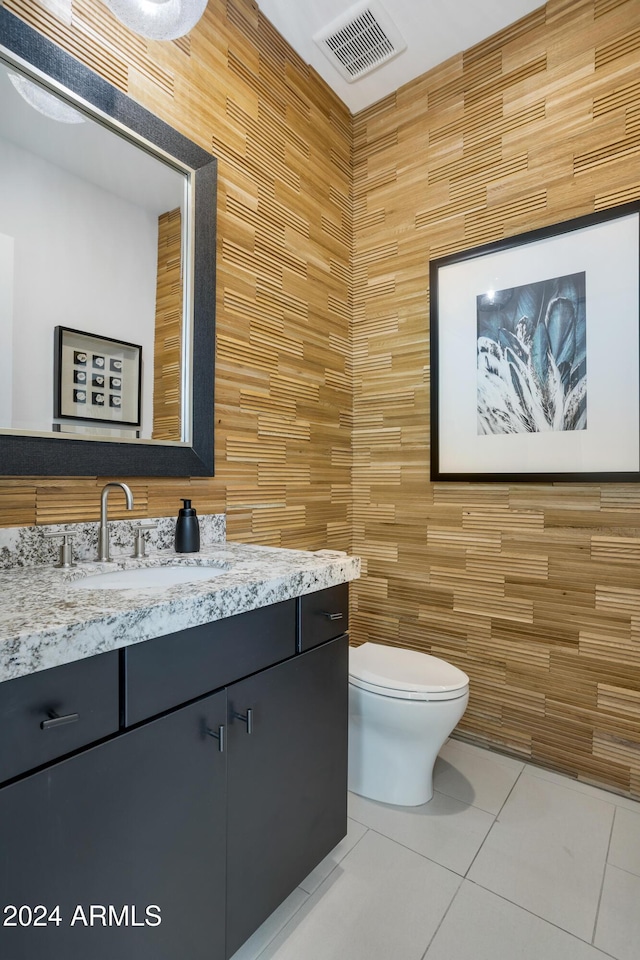 bathroom featuring tile patterned floors, vanity, tile walls, and toilet