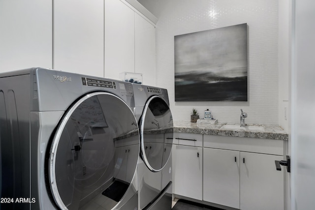 laundry area with washing machine and dryer, sink, and cabinets