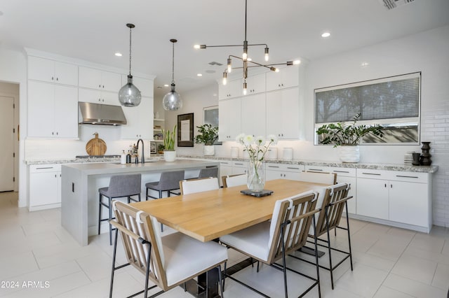 tiled dining space featuring sink and an inviting chandelier