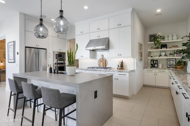 kitchen with a kitchen island with sink, white cabinets, and stainless steel appliances