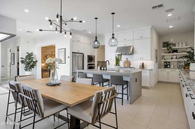 dining area featuring sink, light tile patterned flooring, and a chandelier