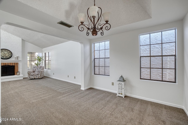 unfurnished living room with carpet flooring, a textured ceiling, and a wealth of natural light