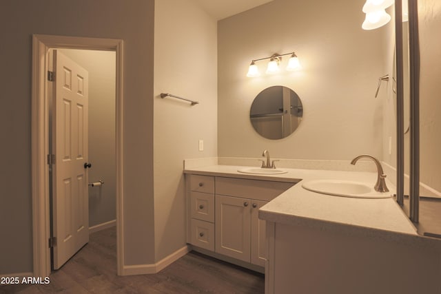 bathroom with vanity, baseboards, and wood finished floors