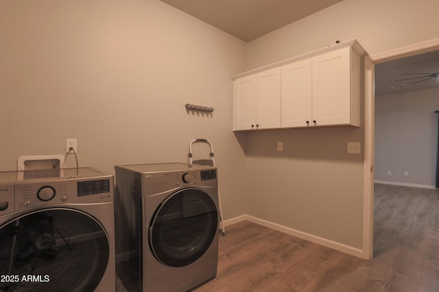 laundry area with ceiling fan, baseboards, washer and dryer, cabinet space, and dark wood-style floors