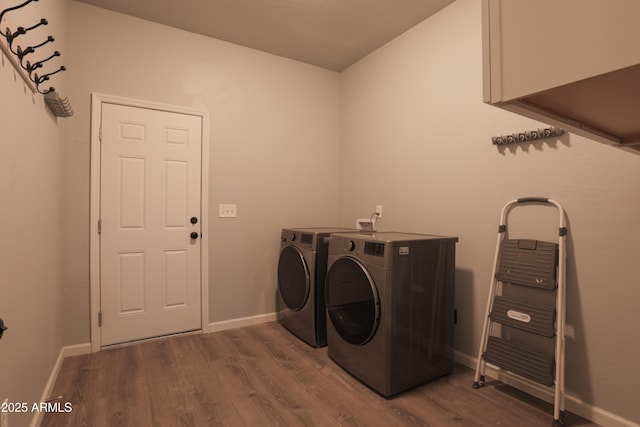 washroom featuring laundry area, baseboards, dark wood-style flooring, and washing machine and clothes dryer