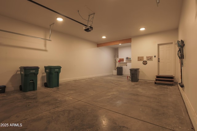 garage featuring baseboards, a garage door opener, and recessed lighting