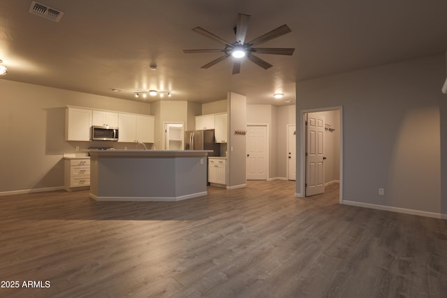 kitchen featuring stainless steel appliances, white cabinets, visible vents, and dark wood-type flooring