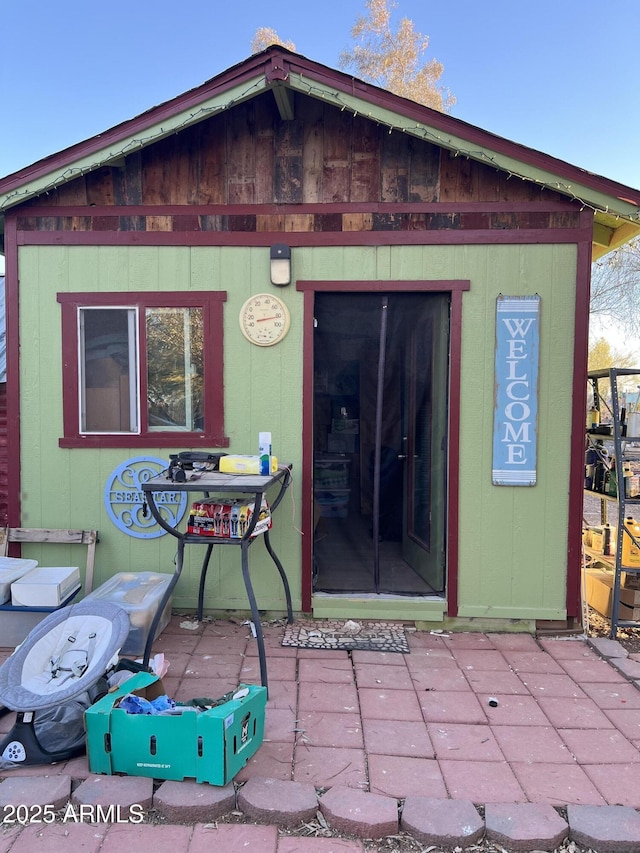 rear view of property with an outdoor structure