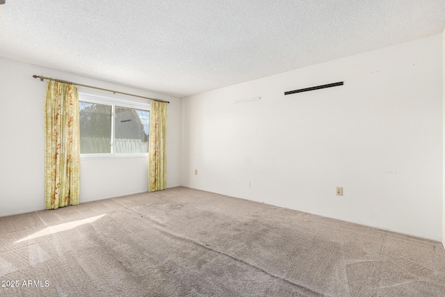 carpeted spare room featuring a textured ceiling