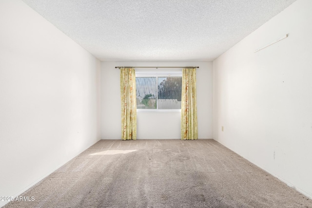 carpeted empty room featuring a textured ceiling