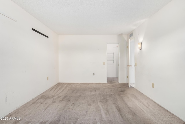 carpeted spare room with a textured ceiling