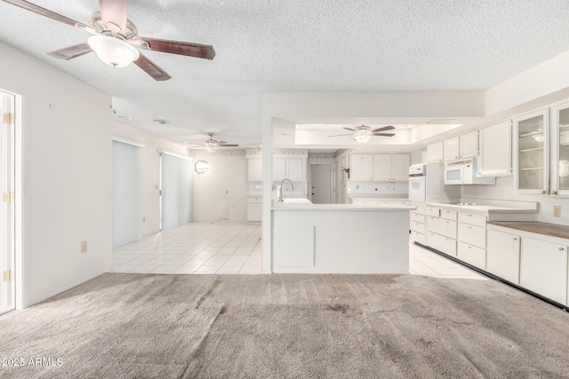 kitchen with sink, white cabinetry, light colored carpet, a textured ceiling, and white appliances