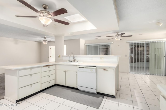 kitchen featuring sink, dishwasher, white cabinets, light tile patterned flooring, and kitchen peninsula