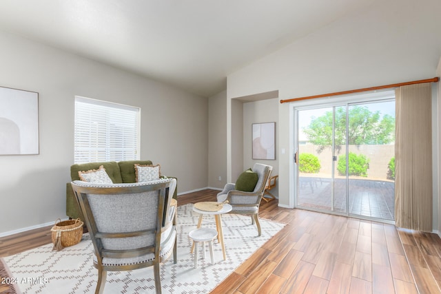 living area with light hardwood / wood-style floors and vaulted ceiling