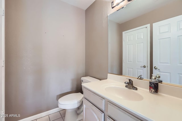 bathroom with toilet, tile patterned flooring, and vanity