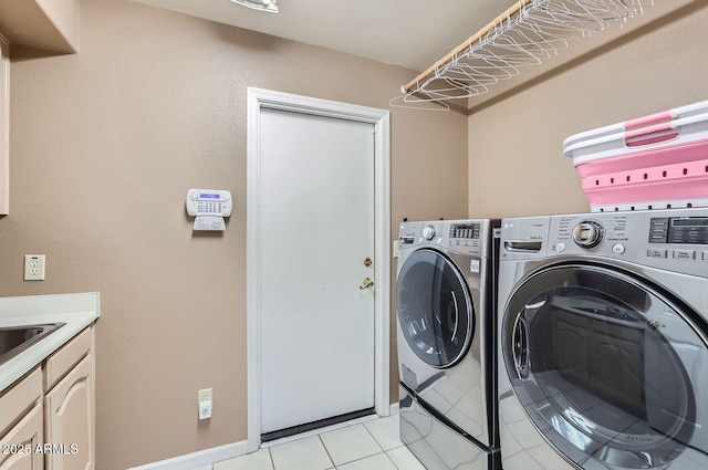 clothes washing area featuring washer and clothes dryer and light tile patterned floors