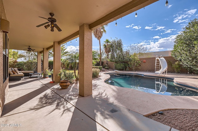 view of swimming pool featuring ceiling fan, a water slide, and a patio