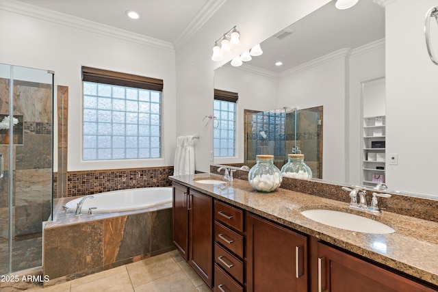 bathroom with a bath, a tile shower, tile patterned flooring, double vanity, and crown molding
