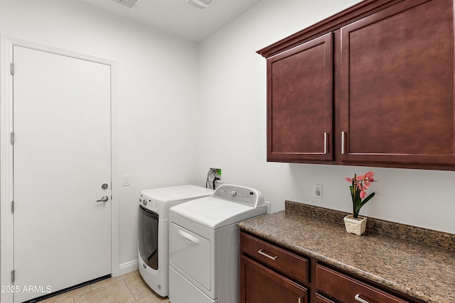 laundry area with separate washer and dryer, cabinet space, and light tile patterned floors