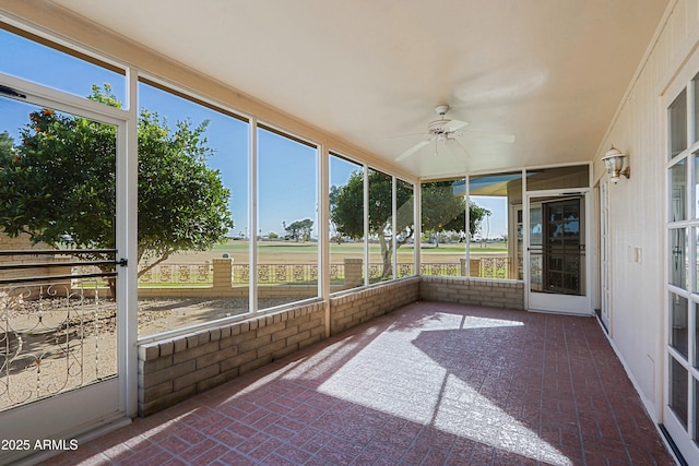 unfurnished sunroom with ceiling fan