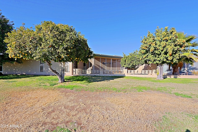 view of front of property featuring a front lawn and a sunroom