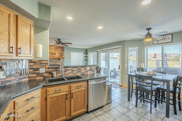 kitchen featuring decorative backsplash, sink, ceiling fan, light tile patterned floors, and stainless steel dishwasher