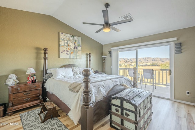 bedroom with ceiling fan, vaulted ceiling, light hardwood / wood-style floors, access to outside, and a mountain view