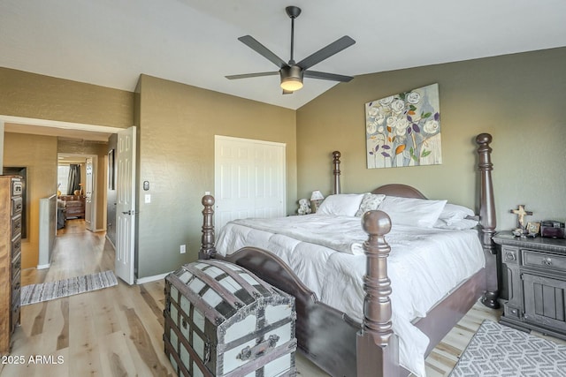 bedroom with ceiling fan, vaulted ceiling, a closet, and light hardwood / wood-style flooring