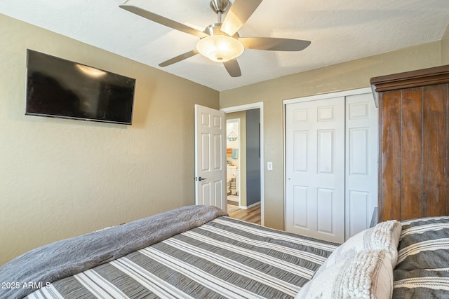 bedroom with ceiling fan, wood-type flooring, and a closet