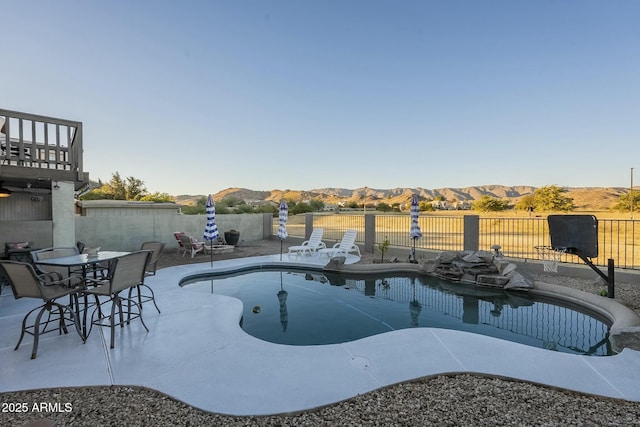 view of swimming pool with a mountain view and a patio area