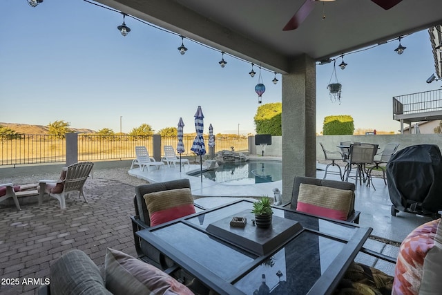 view of patio with ceiling fan, a grill, and a fenced in pool