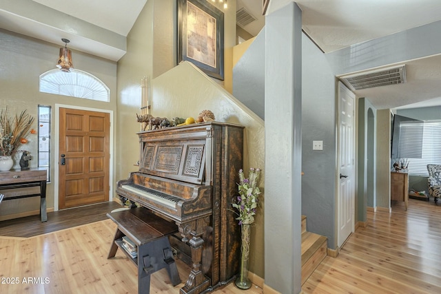 miscellaneous room with a high ceiling and wood-type flooring