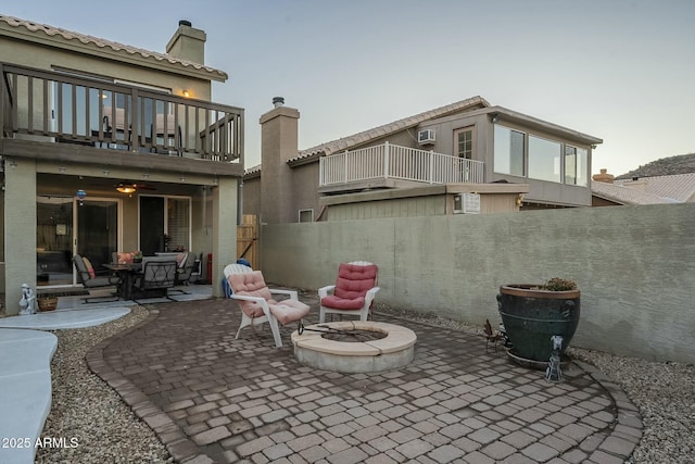 view of patio featuring an outdoor fire pit and a balcony