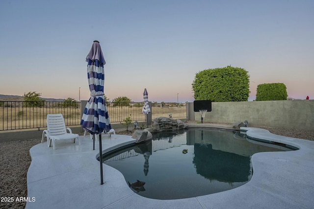 pool at dusk with a patio