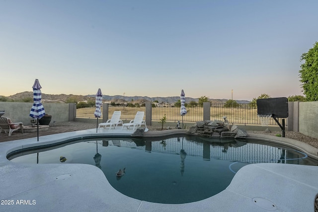 pool at dusk featuring a patio area