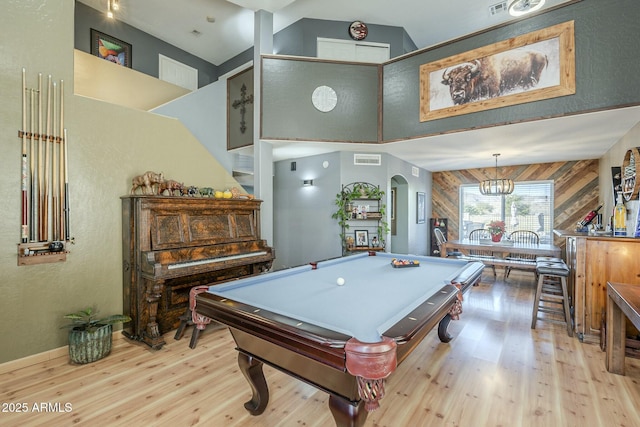 rec room featuring light wood-type flooring, an inviting chandelier, wooden walls, and billiards