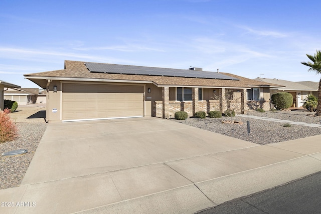 ranch-style house featuring solar panels and a garage