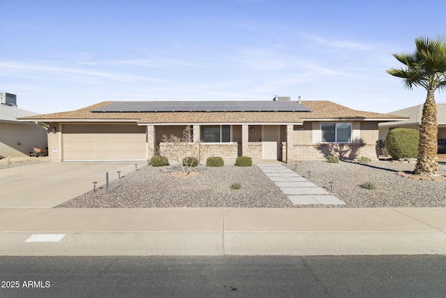 single story home featuring solar panels and a garage