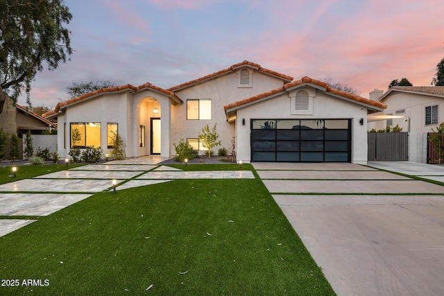 view of front of home featuring a garage and a lawn